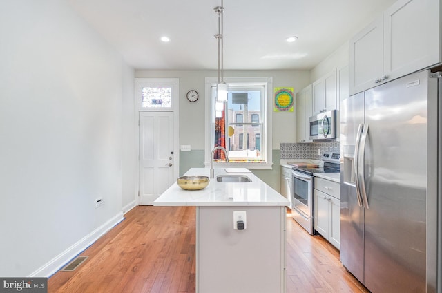 814 N Patterson Park Ave, Baltimore, MD 21205 - kitchen featuring stainless steel appliances, a sink, decorative backsplash, light countertops, and light wood-style flooring