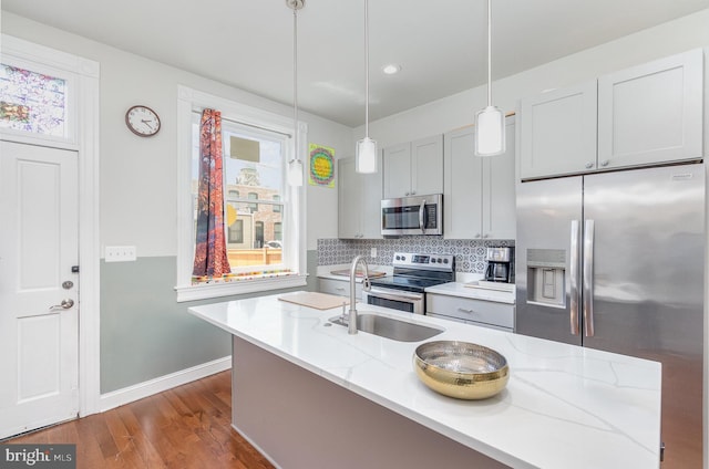 814 N Patterson Park Ave, Baltimore, MD 21205 - kitchen with appliances with stainless steel finishes, dark wood-style floors, backsplash, a sink, and baseboards