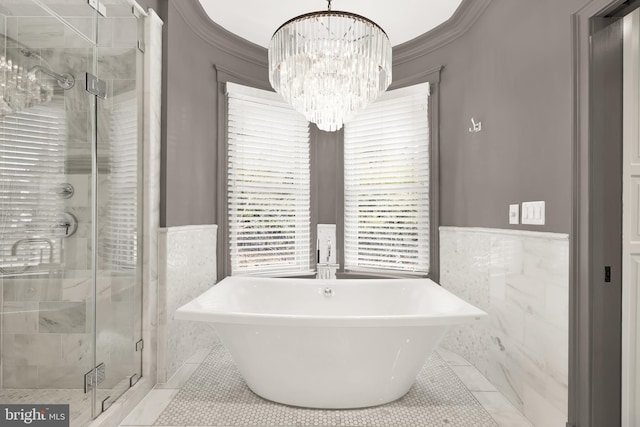 bathroom with tile walls, tile patterned flooring, a chandelier, a shower stall, and wainscoting
