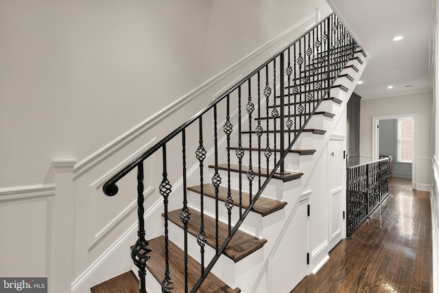 staircase with wood finished floors, ornamental molding, recessed lighting, and baseboards