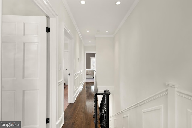 corridor featuring ornamental molding, dark wood finished floors, recessed lighting, a decorative wall, and wainscoting