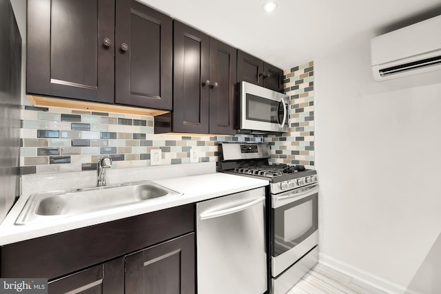 kitchen with stainless steel appliances, a wall mounted air conditioner, a sink, backsplash, and light countertops