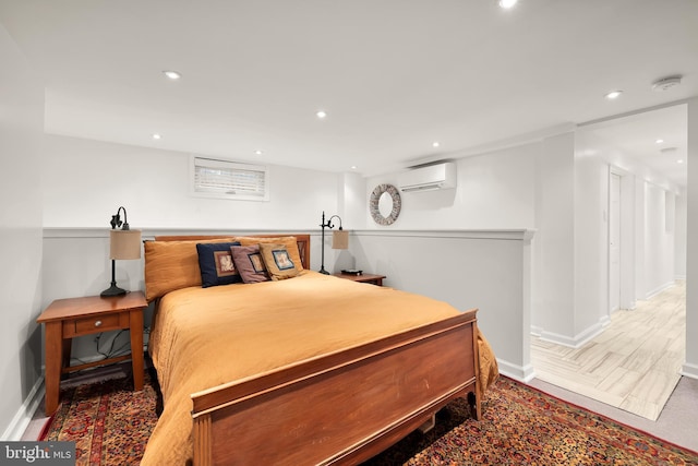 bedroom with a wall unit AC, recessed lighting, and baseboards