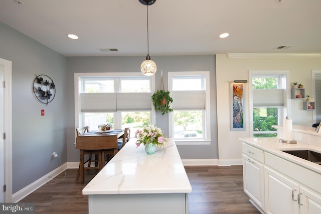 301 Muir St Unit 201, Cambridge, MD 21613 - kitchen featuring plenty of natural light, white cabinets, baseboards, light stone counters, and recessed lighting