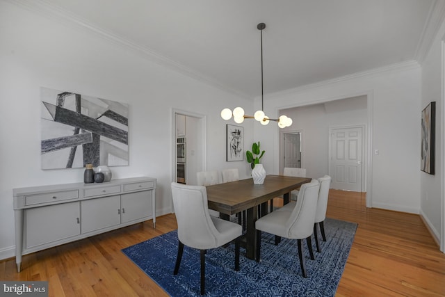 5127 Cathedral Ave NW, Washington, DC 20016 - dining area featuring crown molding, light wood-type flooring, a chandelier, and baseboards