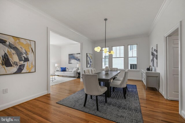 5127 Cathedral Ave NW, Washington, DC 20016 - dining area featuring crown molding, a chandelier, wood finished floors, and baseboards