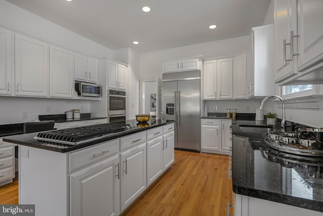 5127 Cathedral Ave NW, Washington, DC 20016 - kitchen featuring appliances with stainless steel finishes, a sink, white cabinets, a kitchen island, and recessed lighting