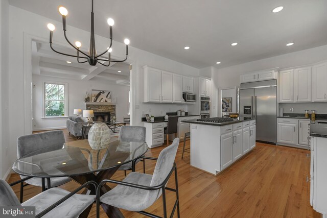 5127 Cathedral Ave NW, Washington, DC 20016 - dining area with recessed lighting, a fireplace, a chandelier, light wood-style floors, and beamed ceiling