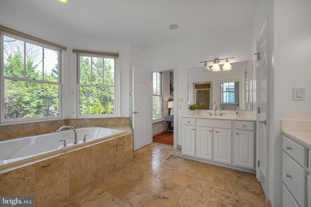 5127 Cathedral Ave NW, Washington, DC 20016 - bathroom featuring vanity, a garden tub, stone tile flooring, and a chandelier