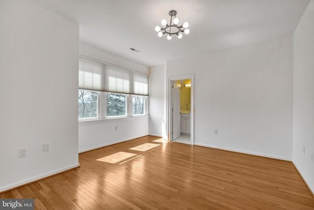5127 Cathedral Ave NW, Washington, DC 20016 - unfurnished bedroom with a chandelier, wood finished floors, baseboards, and ensuite bath