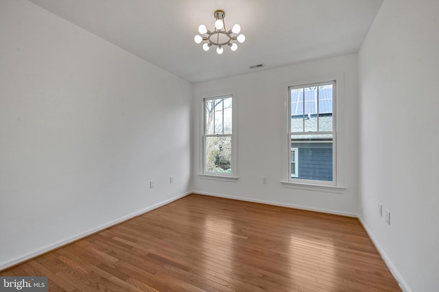 5127 Cathedral Ave NW, Washington, DC 20016 - unfurnished room featuring a chandelier, wood-type flooring, and baseboards