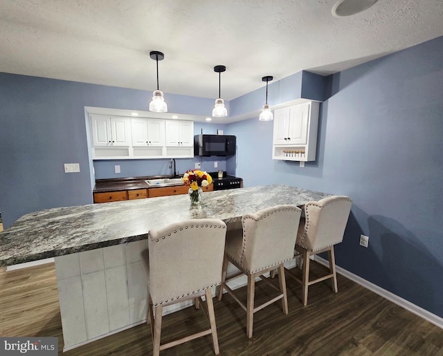 7677 Green Ridge Ln, Abbottstown, PA 17301 - kitchen featuring black microwave, a sink, dark wood finished floors, and a breakfast bar