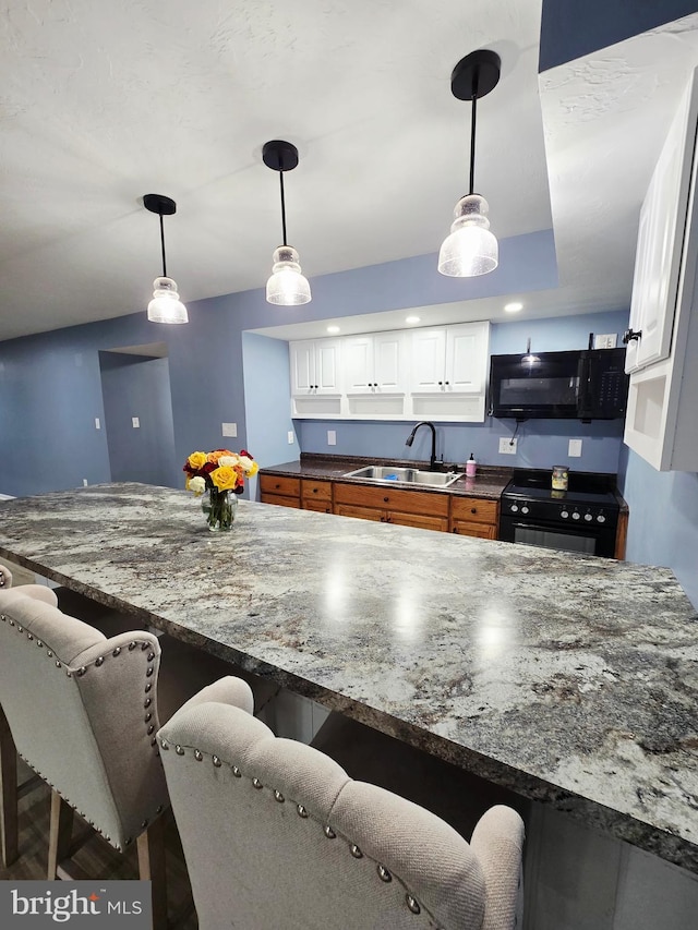 7677 Green Ridge Ln, Abbottstown, PA 17301 - kitchen featuring black appliances, a sink, a breakfast bar area, white cabinets, and dark stone countertops