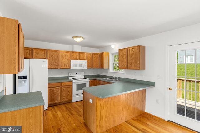 1118 Ashby St, Front Royal, VA 22630 - kitchen featuring white appliances, a peninsula, light wood-style floors, and brown cabinets