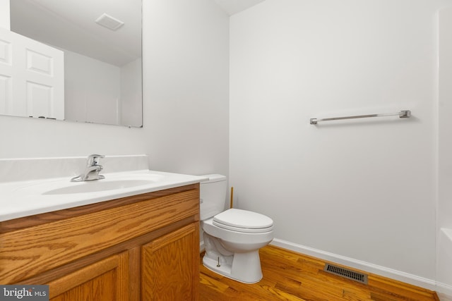 1118 Ashby St, Front Royal, VA 22630 - bathroom with toilet, vanity, wood finished floors, and baseboards