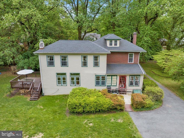 61 Park Rd, Reading, PA 19609 - view of front of house with a chimney, a deck, a front lawn, and view of wooded area