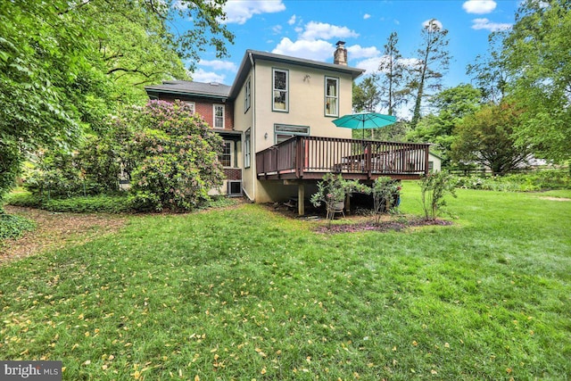 61 Park Rd, Reading, PA 19609 - back of house featuring a chimney, a wooden deck, a lawn, central air condition unit, and stucco siding