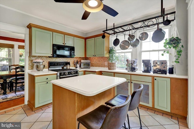 61 Park Rd, Reading, PA 19609 - kitchen with stainless steel range with gas cooktop, black microwave, green cabinets, ceiling fan, and light tile patterned floors