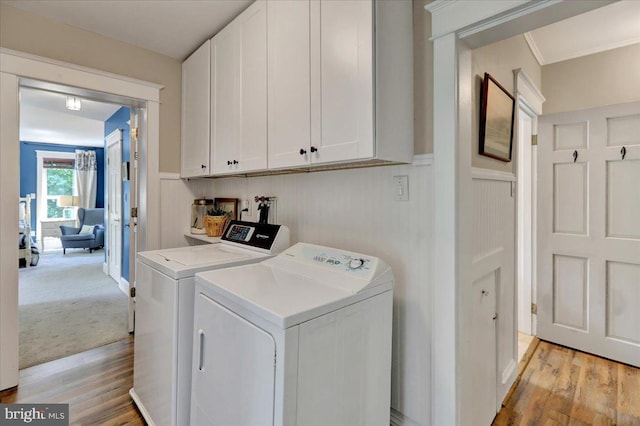 61 Park Rd, Reading, PA 19609 - washroom featuring washing machine and dryer, cabinet space, light wood-style floors, wainscoting, and a decorative wall