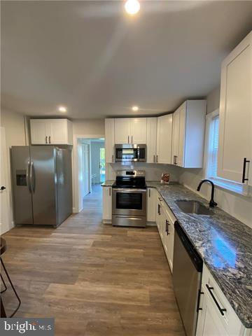 31 E Goepp St, Bethlehem, PA 18018 - kitchen featuring stainless steel appliances, a sink, white cabinetry, dark stone countertops, and recessed lighting