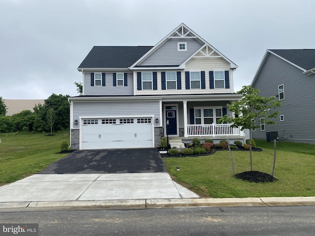 craftsman inspired home featuring covered porch, driveway, a front yard, and an attached garage