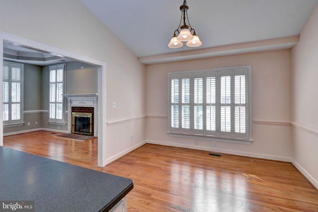 3609 Bradinton, Williamsburg, VA 23188 - unfurnished living room with light wood-type flooring, a glass covered fireplace, baseboards, and lofted ceiling