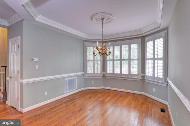 3609 Bradinton, Williamsburg, VA 23188 - spare room with a tray ceiling, ornamental molding, a chandelier, plenty of natural light, and wood finished floors