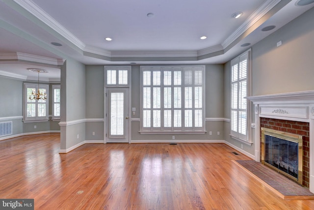 3609 Bradinton, Williamsburg, VA 23188 - unfurnished living room featuring a chandelier, wood finished floors, a fireplace, a raised ceiling, and crown molding