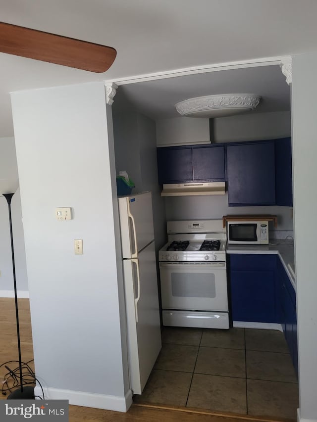 4410 Falls Bridge Dr Unit H, Baltimore, MD 21211 - kitchen featuring white appliances, under cabinet range hood, dark tile patterned flooring, light countertops, and blue cabinetry