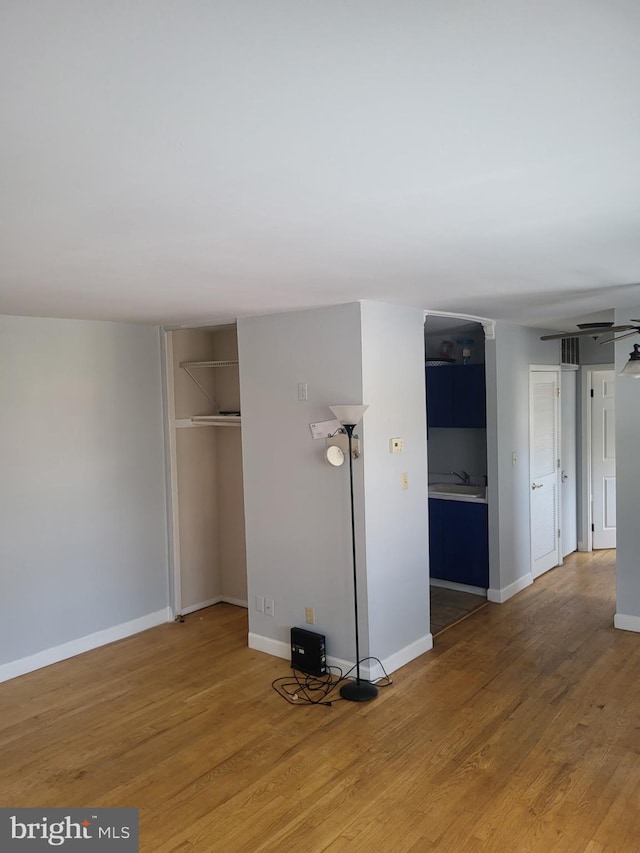 4410 Falls Bridge Dr Unit H, Baltimore, MD 21211 - unfurnished living room featuring wood finished floors, baseboards, and a sink