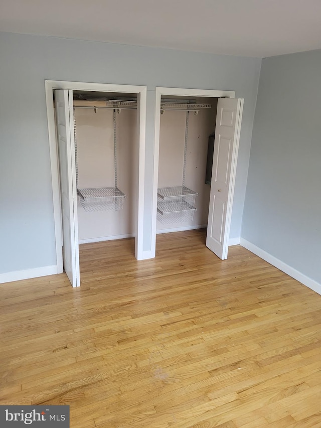 4410 Falls Bridge Dr Unit H, Baltimore, MD 21211 - unfurnished bedroom with multiple closets, baseboards, and light wood-style flooring