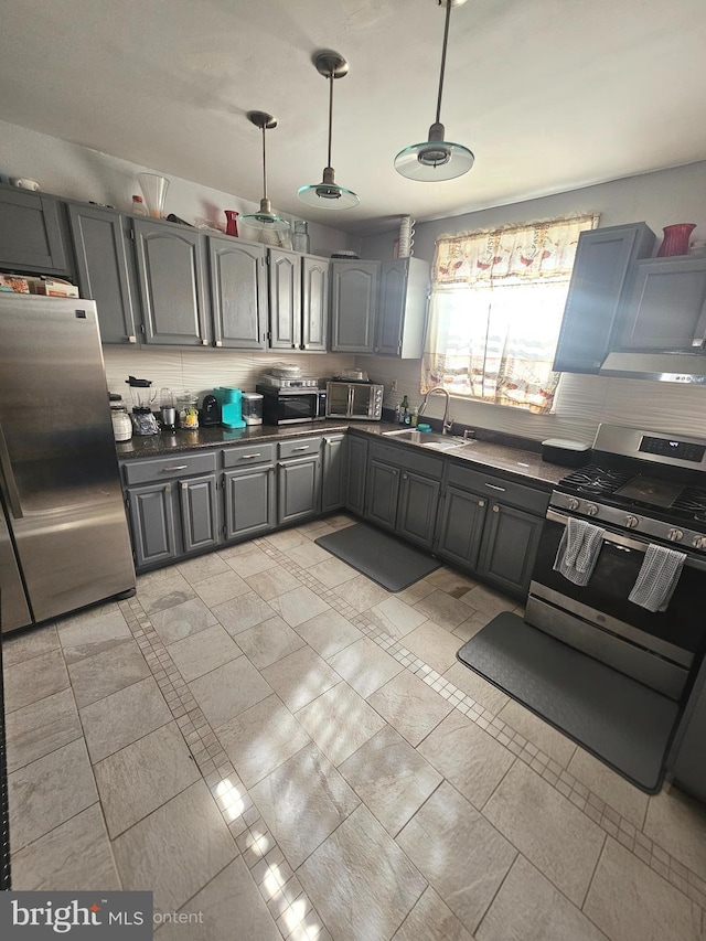 3908 Bennington St, Philadelphia, PA 19124 - kitchen featuring appliances with stainless steel finishes, a sink, dark countertops, gray cabinets, and hanging light fixtures