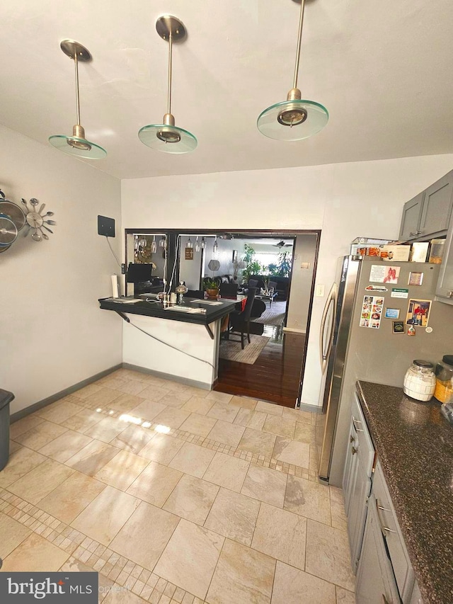 3908 Bennington St, Philadelphia, PA 19124 - kitchen featuring hanging light fixtures, baseboards, and dark stone counters
