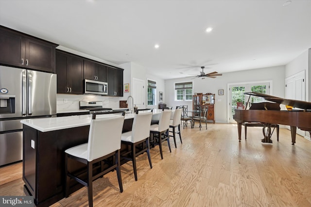 404 Rock Run Cir, Broomall, PA 19008 - kitchen with appliances with stainless steel finishes, an island with sink, a ceiling fan, a breakfast bar area, and light countertops