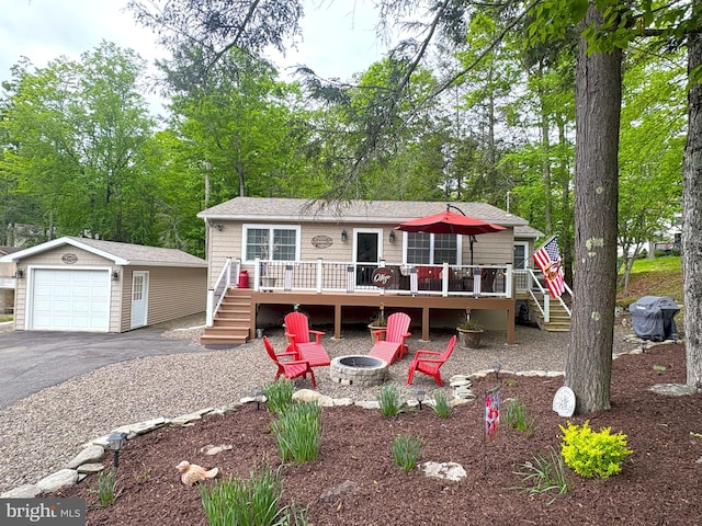 manufactured / mobile home featuring stairway, a garage, a fire pit, and a wooden deck
