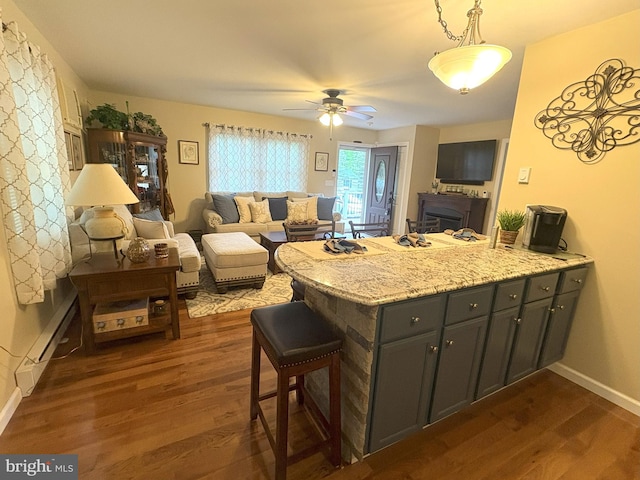 kitchen with a peninsula, dark wood-style flooring, open floor plan, and a ceiling fan