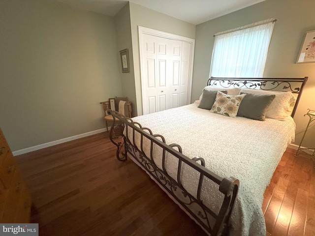 bedroom with baseboards, wood finished floors, and a closet