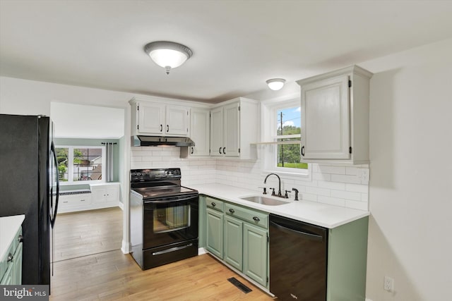 322 S Progress Ave, Harrisburg, PA 17109 - kitchen with black appliances, under cabinet range hood, a sink, and backsplash
