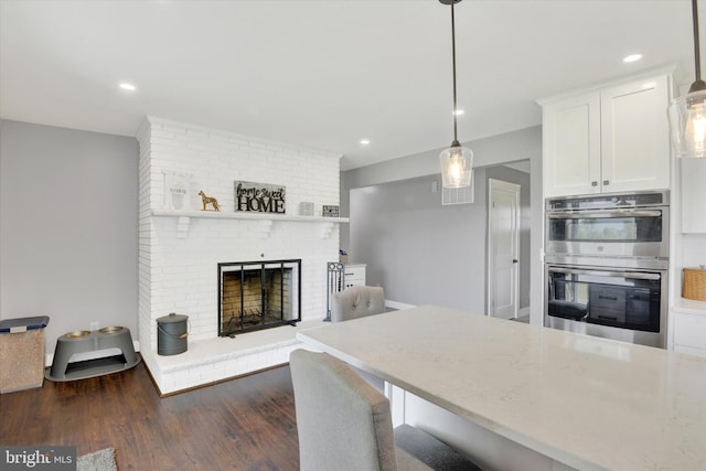 16010 Four Points Bridge Rd, Emmitsburg, MD 21727 - kitchen featuring double oven, white cabinets, dark wood-type flooring, light stone countertops, and a fireplace