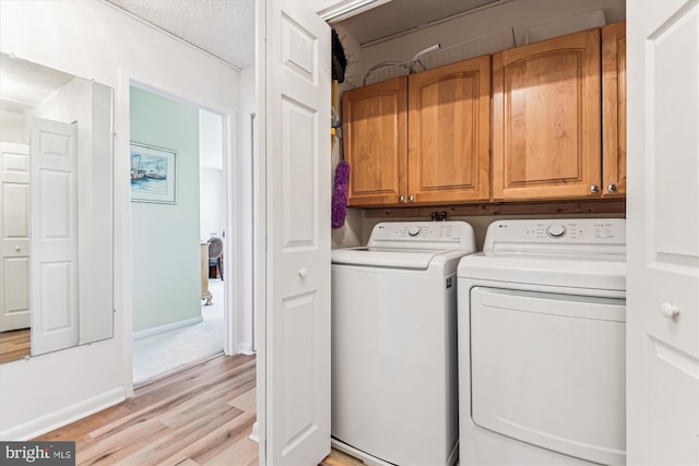 205 E Joppa Rd Unit 403, Baltimore, MD 21286 - laundry area with cabinet space, washer and clothes dryer, light wood finished floors, a textured ceiling, and baseboards