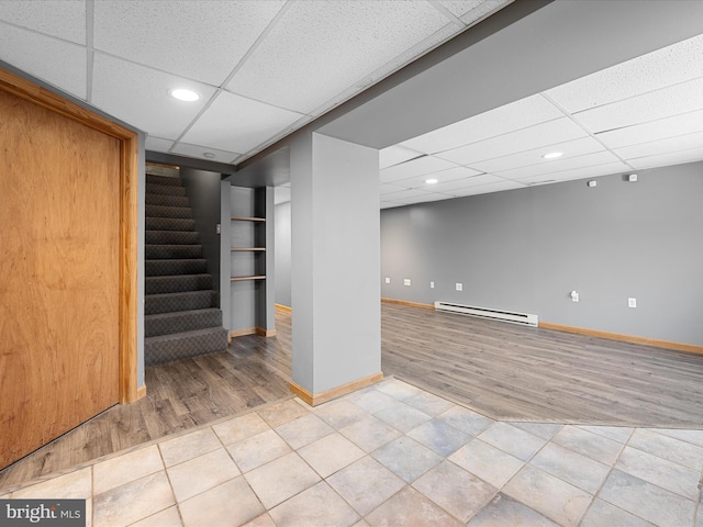 979 John Brown Farm Rd, Harpers Ferry, WV 25425 - finished below grade area featuring a baseboard radiator, a paneled ceiling, baseboards, wood finished floors, and stairway