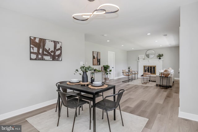 2017 Fairlane Rd, Bel Air, MD 21015 - dining area with light wood-type flooring, baseboards, a chandelier, recessed lighting, and a fireplace