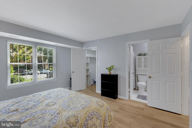 8822 Tanglewood Ln, Manassas, VA 20110 - bedroom with light wood-type flooring, a walk in closet, baseboards, and ensuite bathroom