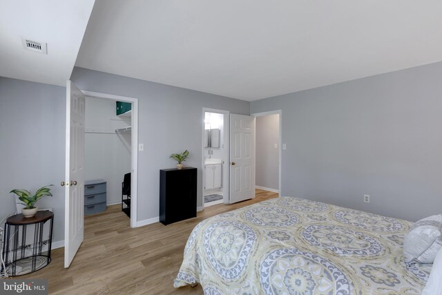 8822 Tanglewood Ln, Manassas, VA 20110 - bedroom with light wood-type flooring, a spacious closet, a closet, baseboards, and ensuite bath