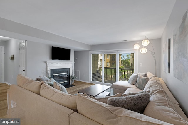 8822 Tanglewood Ln, Manassas, VA 20110 - living area featuring wood finished floors, a fireplace with flush hearth, and baseboards