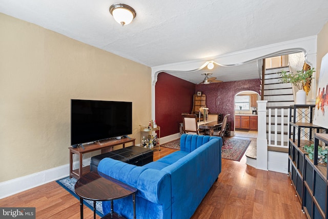 1409 S Clarion St, Philadelphia, PA 19147 - living room with arched walkways, wood finished floors, stairs, baseboards, and a textured ceiling