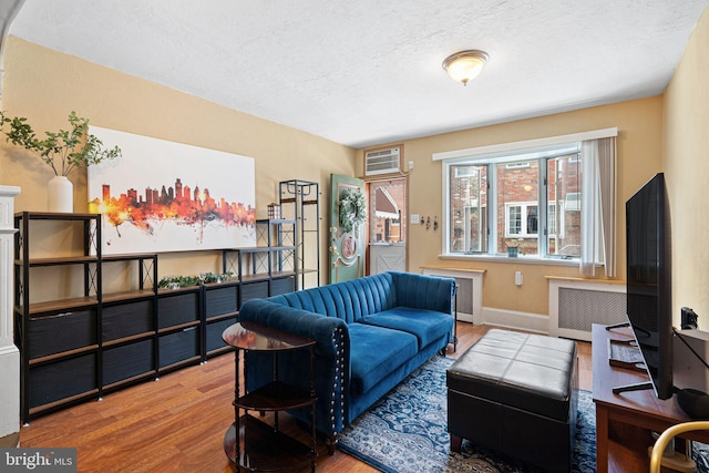 1409 S Clarion St, Philadelphia, PA 19147 - living room with wood finished floors, a textured ceiling, radiator heating unit, baseboards, and a wall mounted air conditioner
