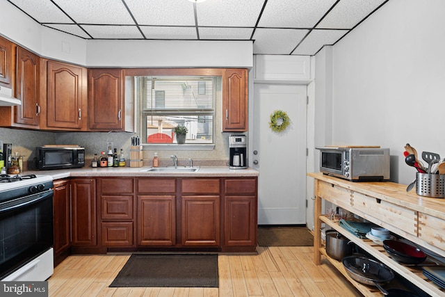 1409 S Clarion St, Philadelphia, PA 19147 - kitchen with gas range oven, a sink, black microwave, a drop ceiling, and light wood-type flooring