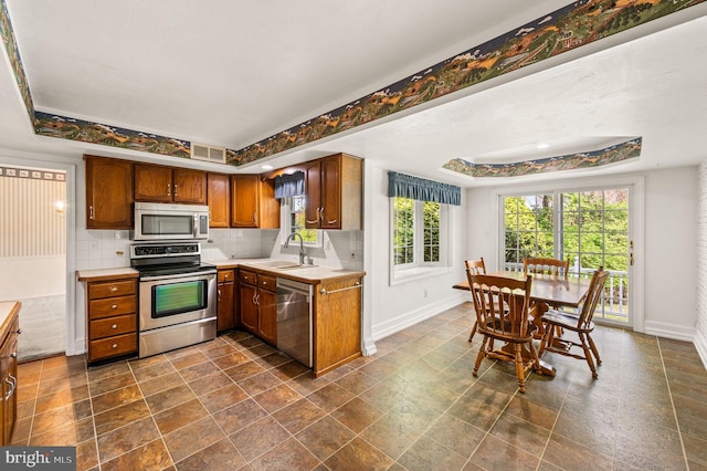 1050 Powderhorn Dr, Glen Mills, PA 19342 - kitchen with appliances with stainless steel finishes, a tray ceiling, a sink, and baseboards