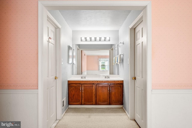1050 Powderhorn Dr, Glen Mills, PA 19342 - bathroom with wallpapered walls, double vanity, and wainscoting